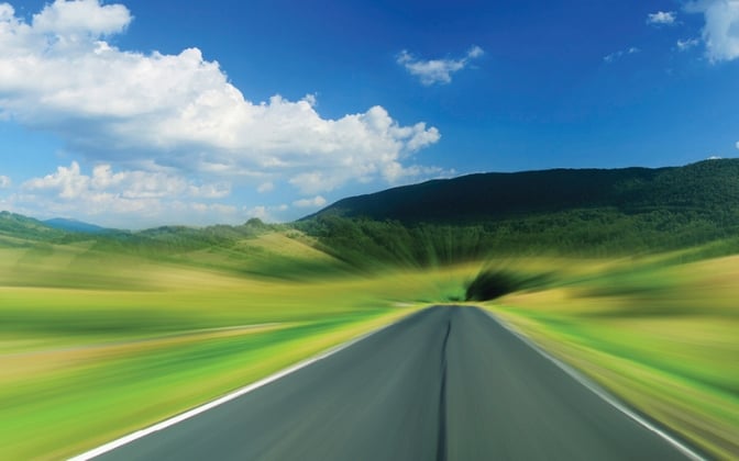 Road with green fields on both sides